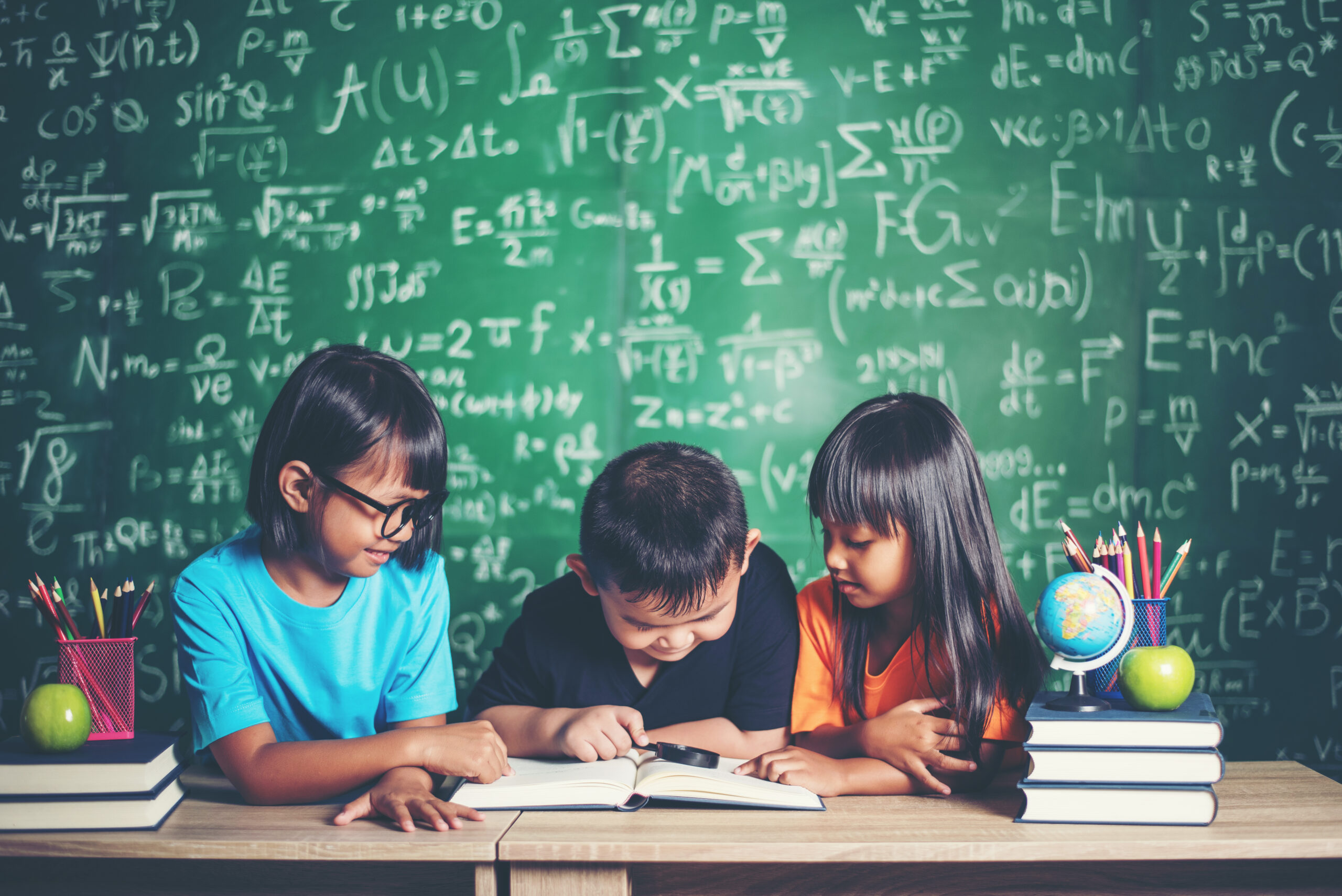 pupils reading a book in the classroom.